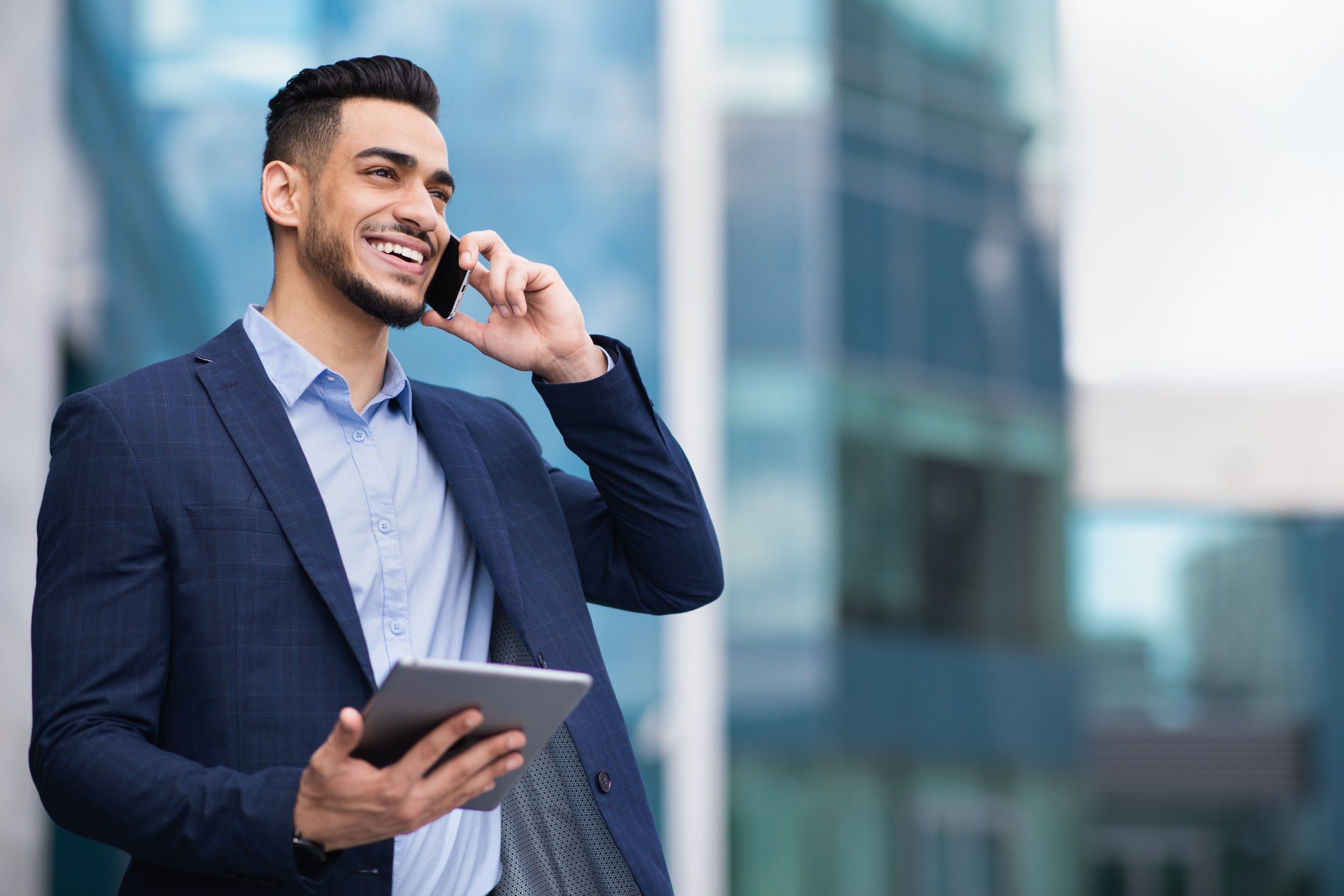 Smiling business man using two phones at one time